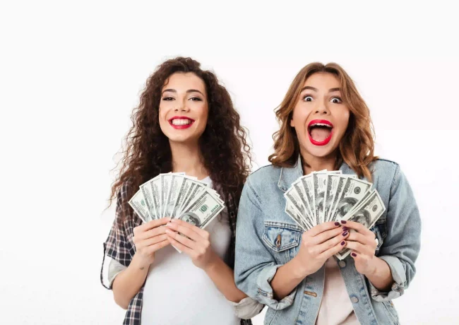 two-happy-girls-holding-money-rejoices-white-wall_resultado