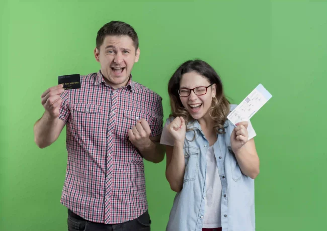 young-couple-man-woman-casual-clothes-happy-man-holding-credit-card-while-his-girlfriend-holding-air-tickets-happy-excited-standing-green-wall_resultado